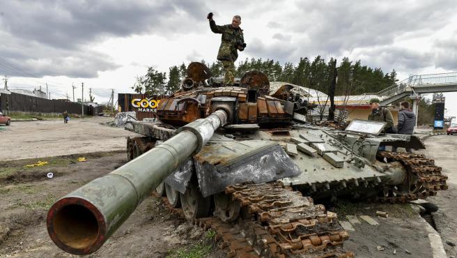 un hombre sobre un tanque ruso destruidos en buzova cerca de kiev